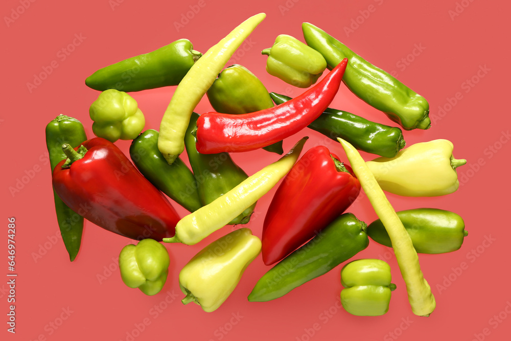 Different fresh peppers on red background