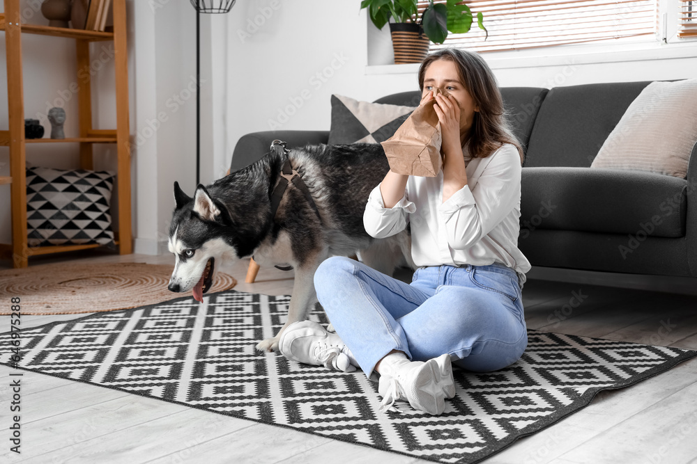 Depressed young woman with husky dog at home