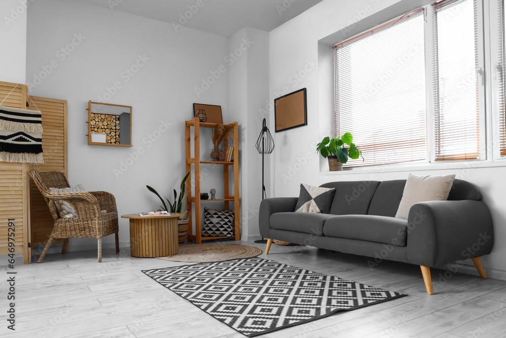 Modern interior of living room with grey sofa and wooden furniture