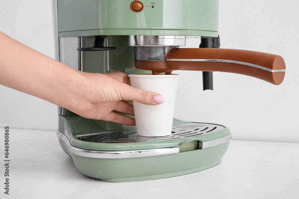 Woman preparing hot coffee on white background