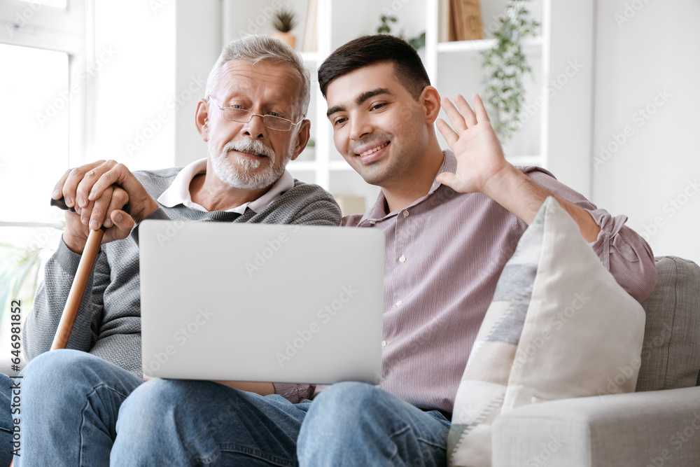 Senior man with his son video chatting at home