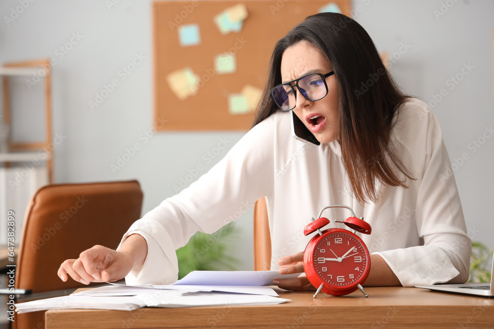 Stressed young businesswoman working under deadline in office