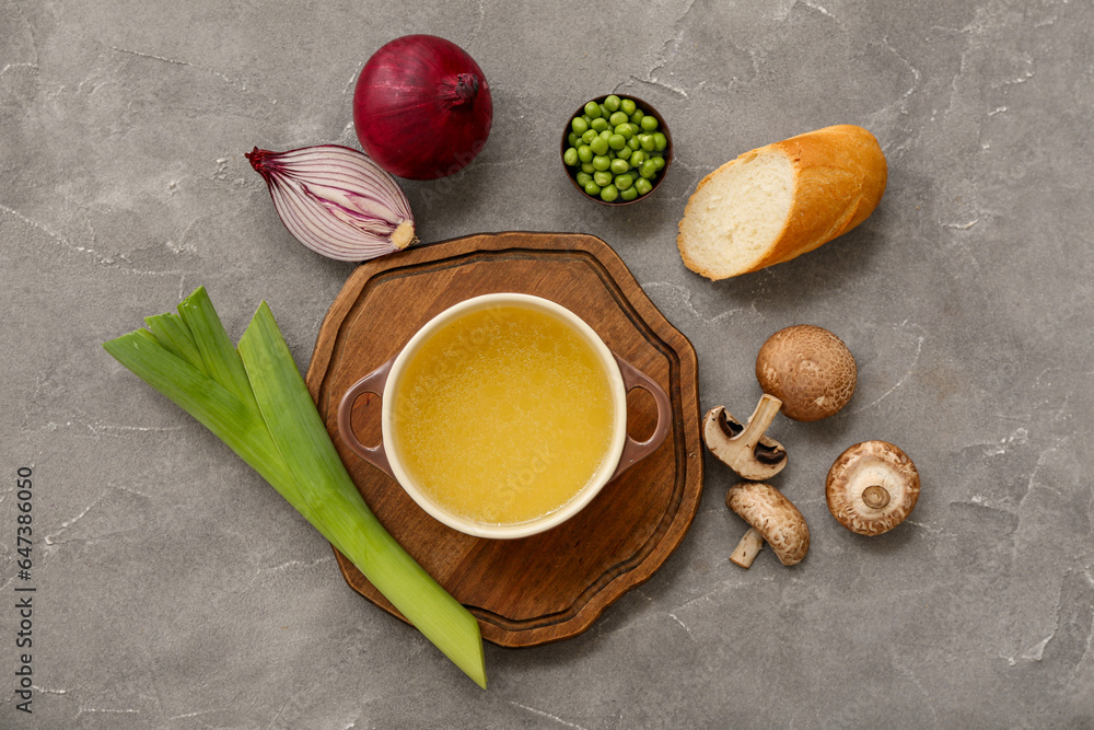 Pot of tasty vegetable broth on grey background