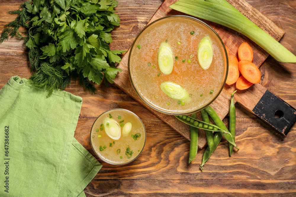 Bowls of tasty vegetable broth on wooden background