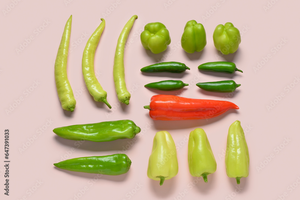 Different fresh peppers on pink background