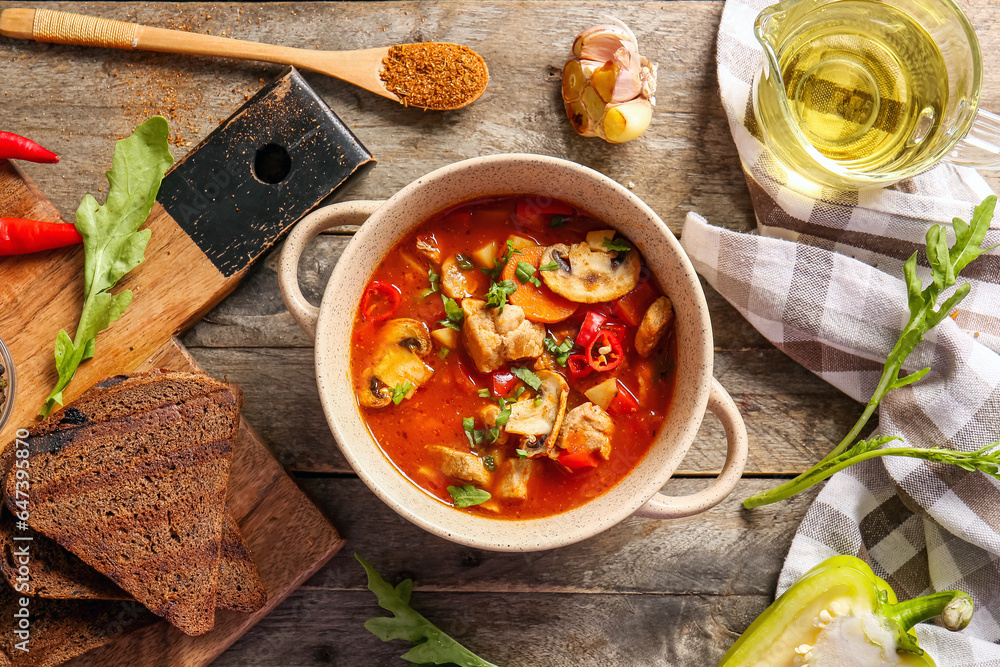 Pot of tasty beef stew on wooden background