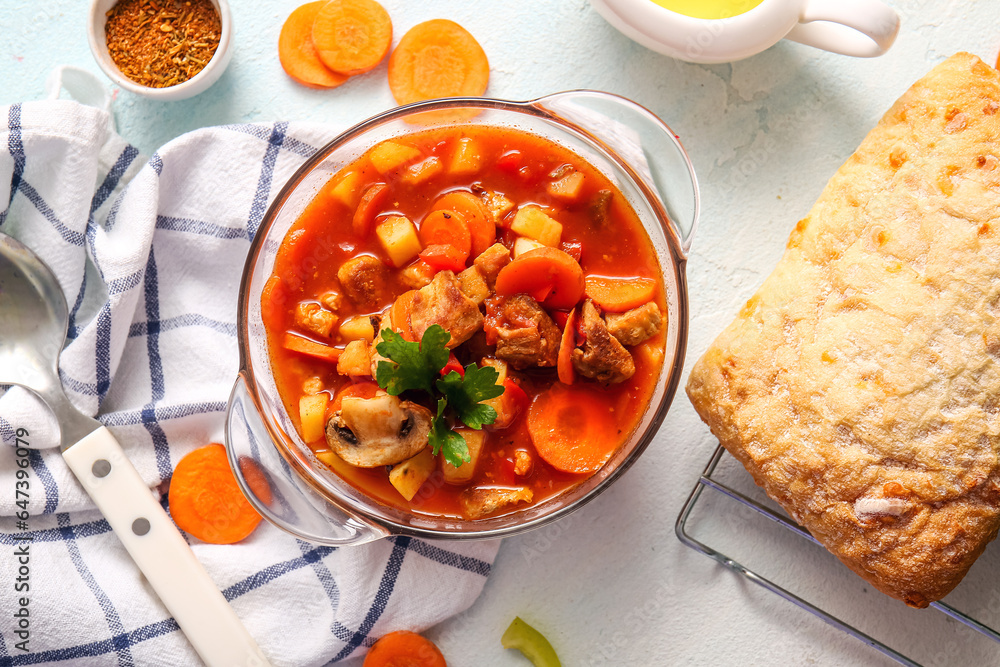 Pot of tasty beef stew on white background