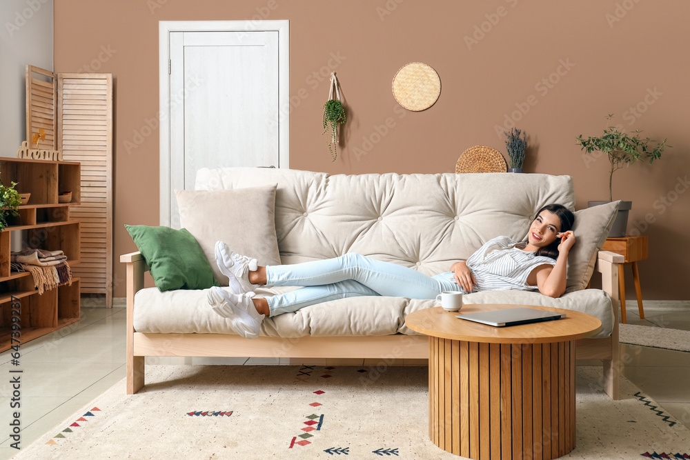 Young woman lying on couch in living room