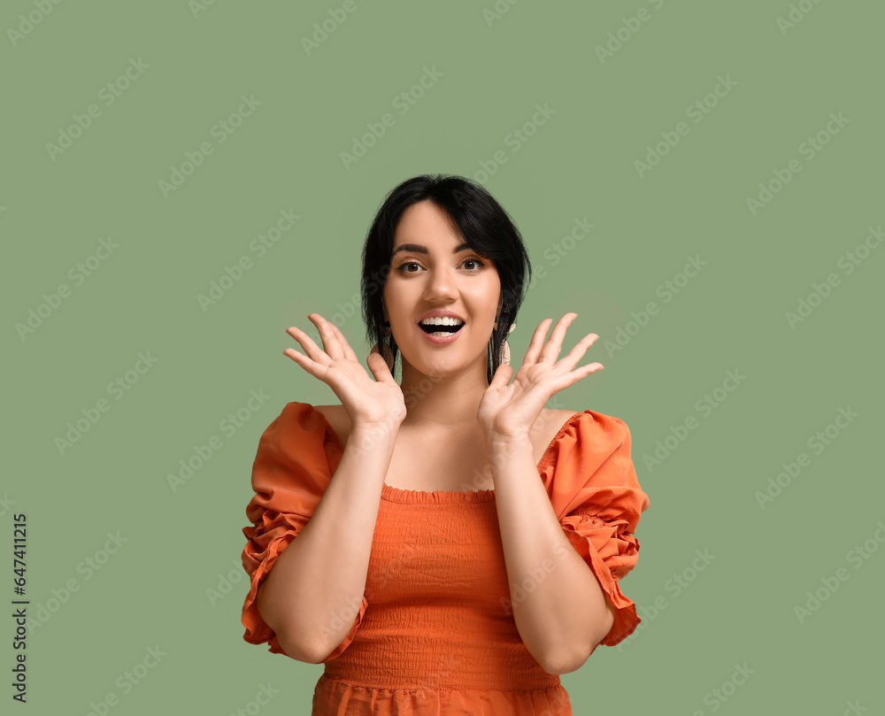 Portrait of happy young brunette on green background