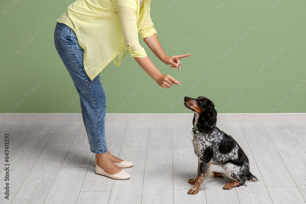 Female dog handler training pet at home