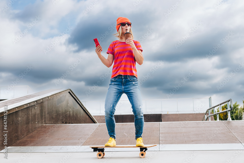 Portrait Of Skater Girl In Skatepark. Female Teenager In Casual Outfit standing On Skateboard on sum