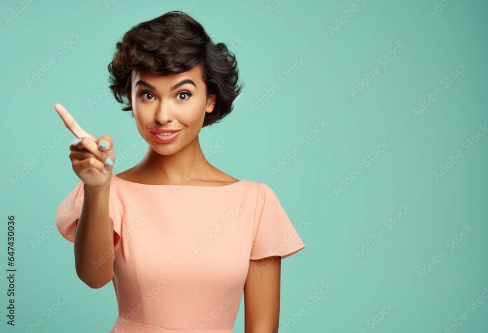 Attractive girl wearing a pink dress pointing at camera