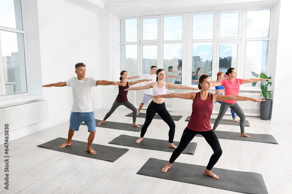 Group of people practicing yoga on mats indoors