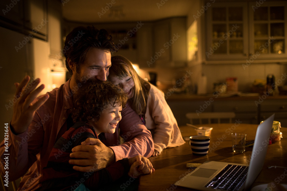 Young family watching a movie on the laptop at night at home