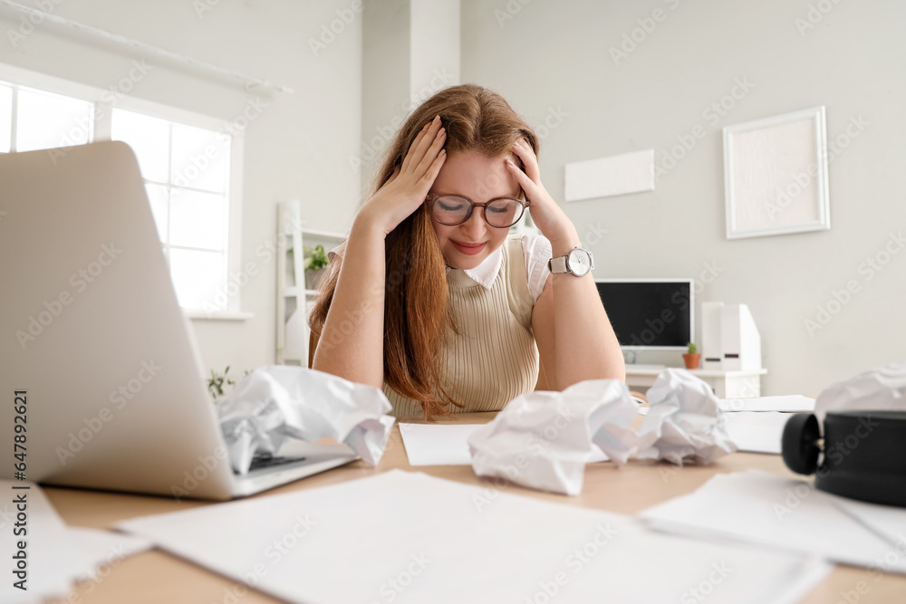 Stressed young businesswoman working under deadline in office