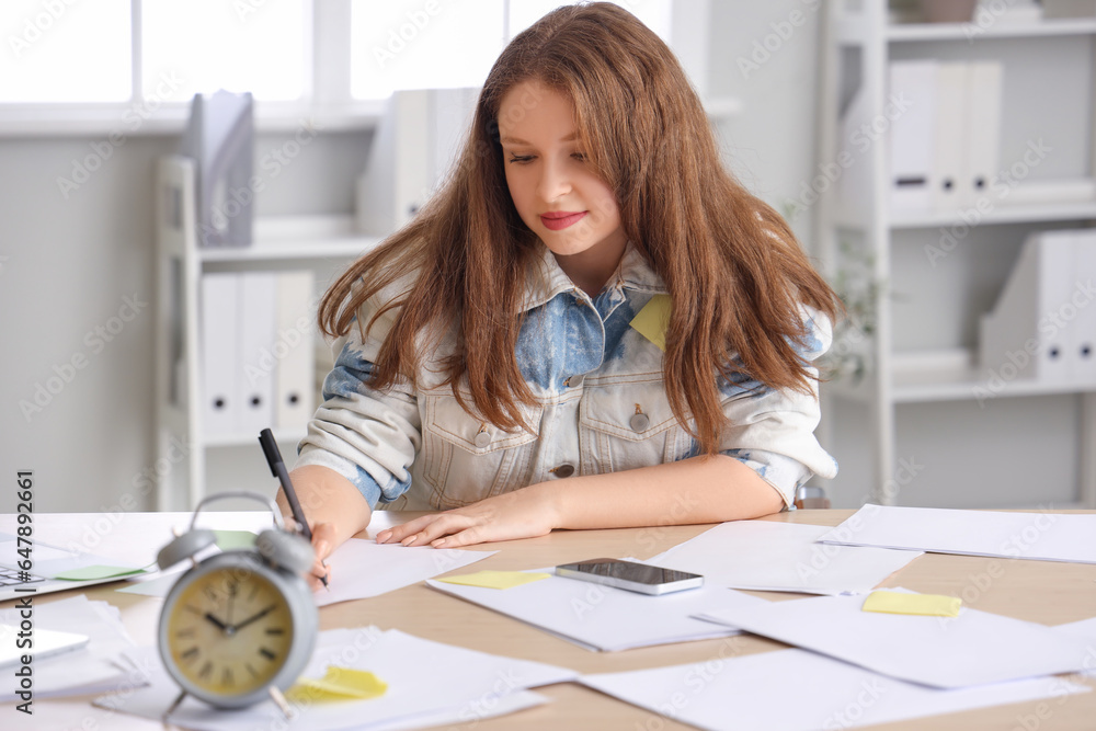 Stressed young businesswoman working under deadline in office