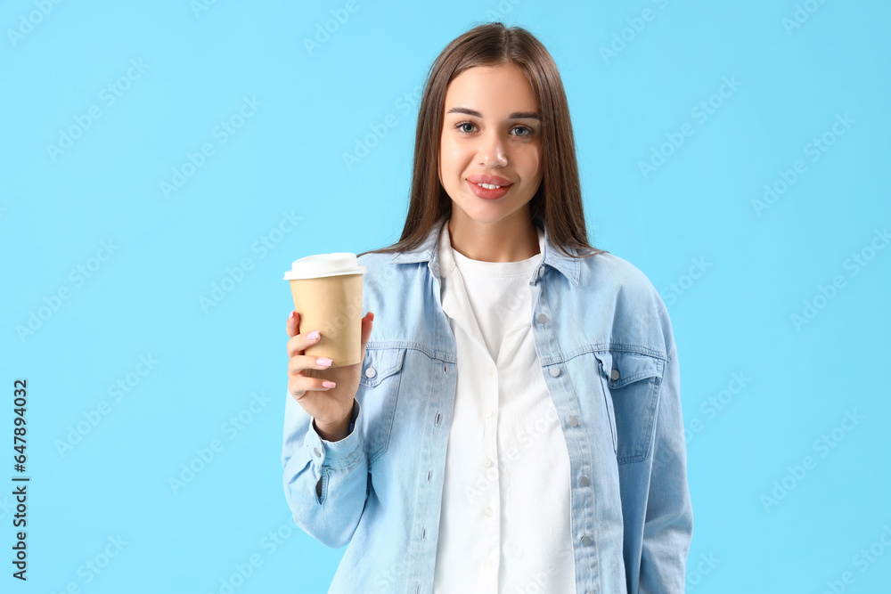 Young woman with cup of coffee on blue background