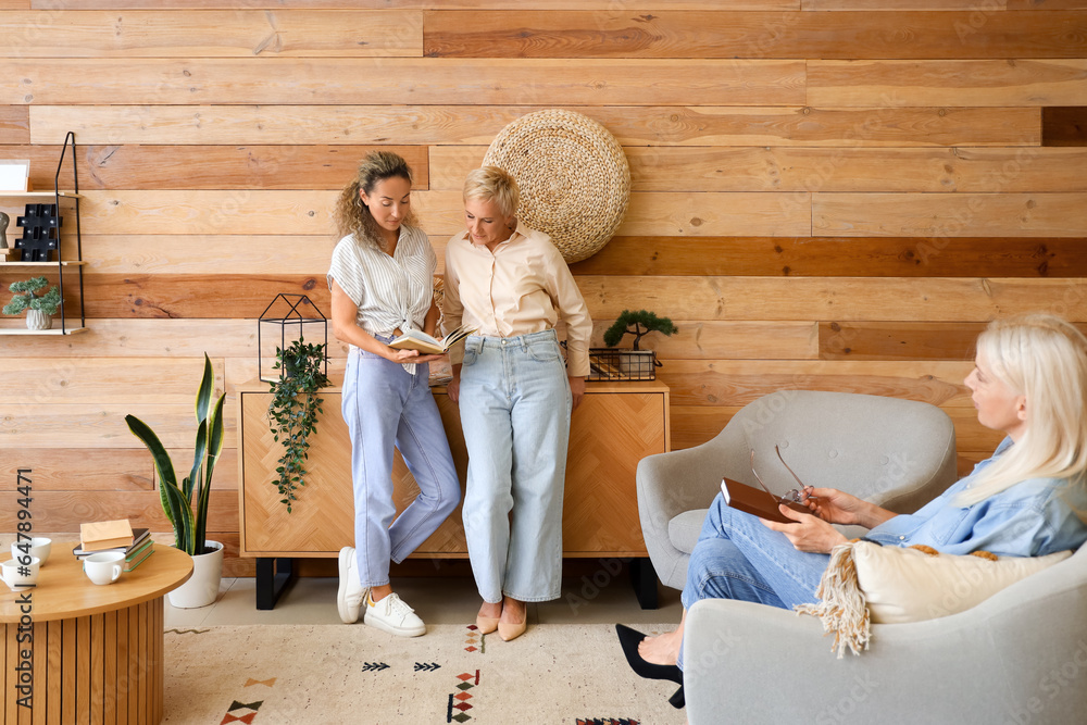 Mature women taking part in book club at home