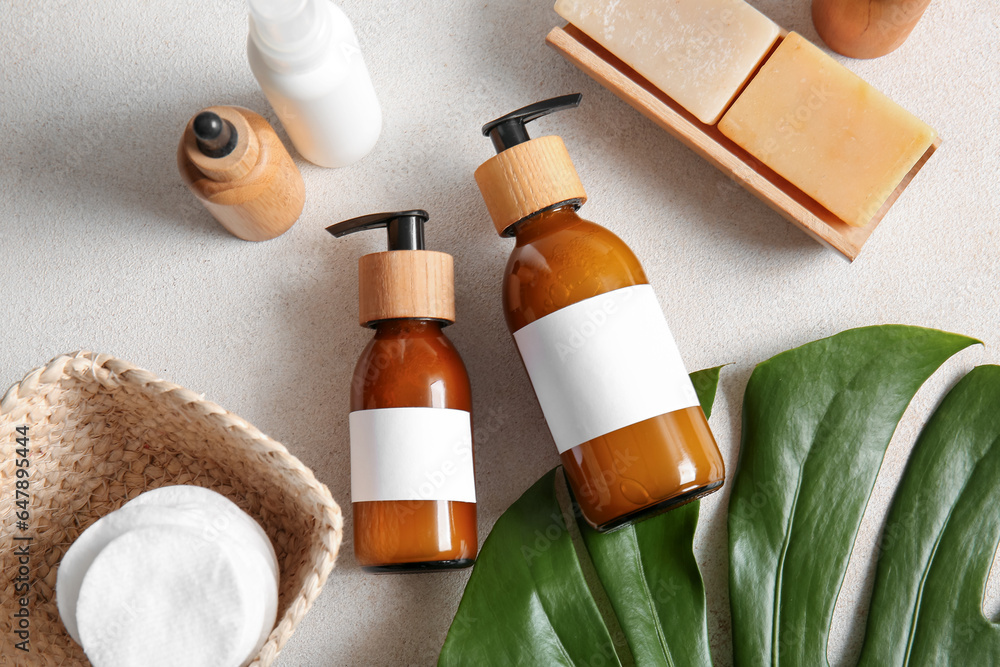 Bottles of shampoo, soap and cotton pads on white background