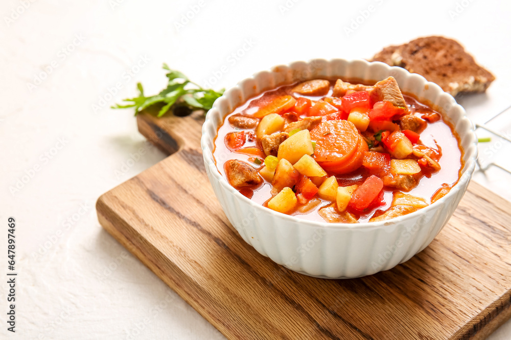 Bowl of tasty beef stew on white background