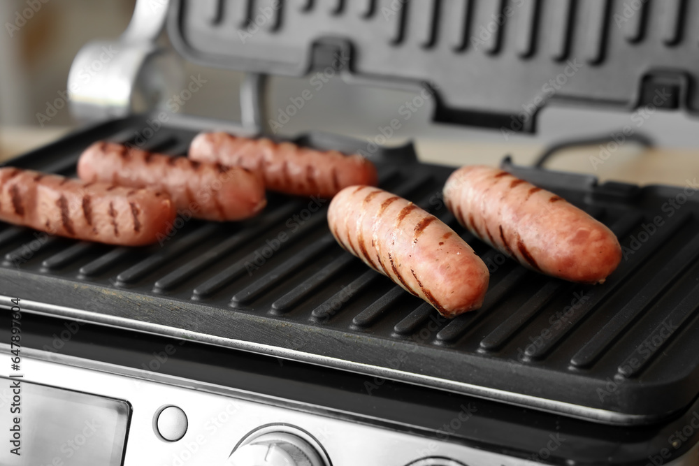 Modern electric grill with tasty sausages, closeup