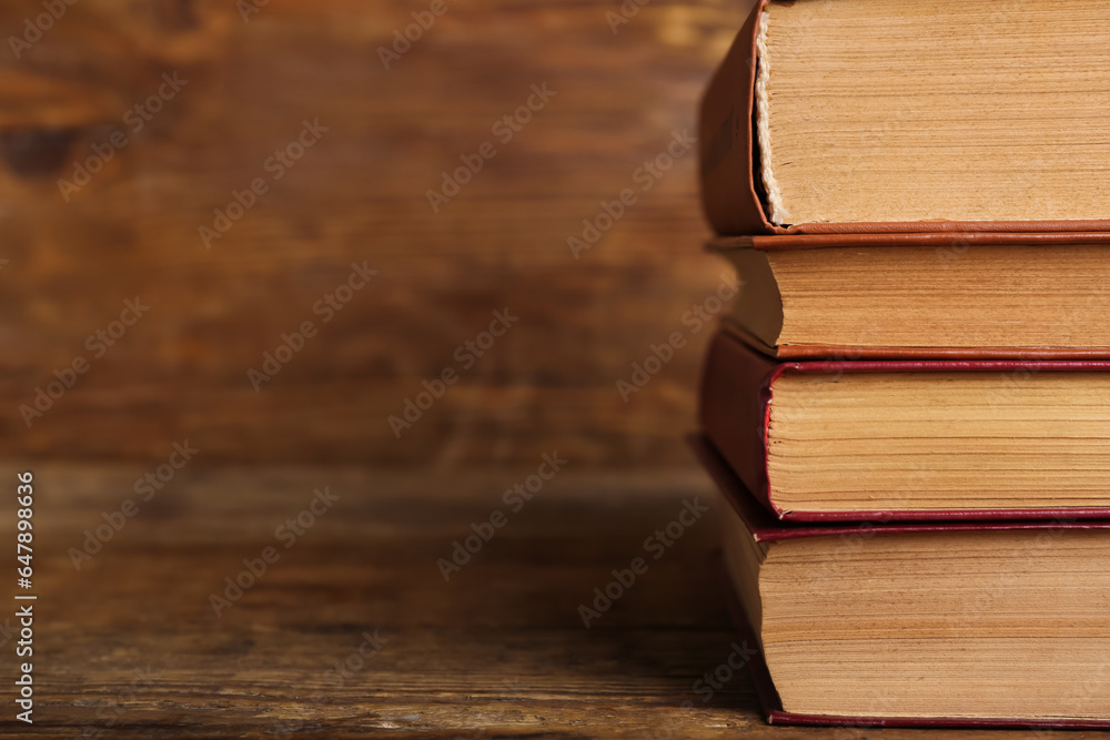 Stack of old hardcover books on wooden background, closeup