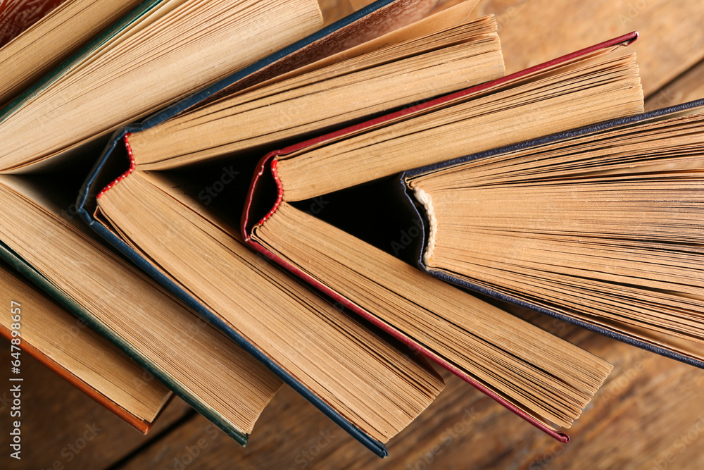 Old hardcover books on wooden background, closeup