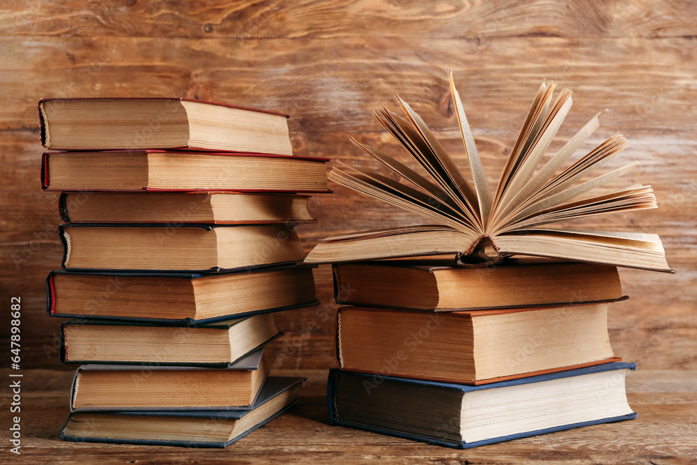 Stacks of old hardcover books on wooden background