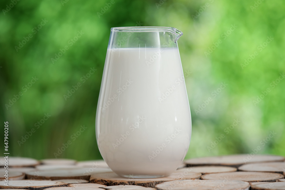 Jug of fresh milk on wooden table outdoors