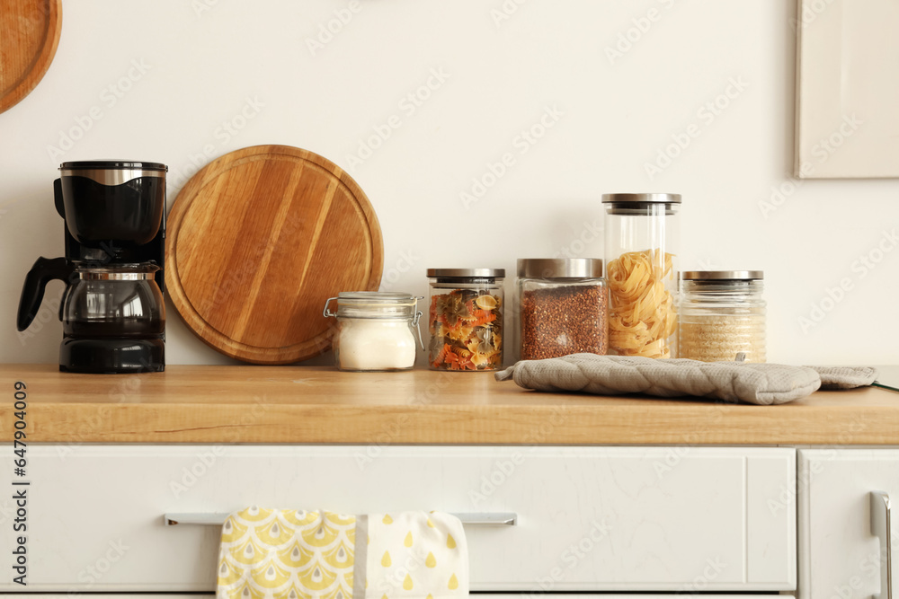 Jars of food with coffee maker on counter in kitchen