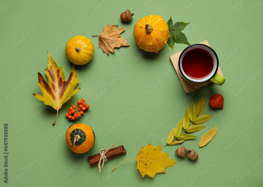 Frame made of natural forest decor, pumpkins and cup of tea on color background