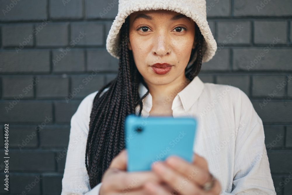 Portrait of girl with phone, brick wall and urban fashion for social media, typing chat or post online. Streetwear, gen z woman or influencer on smartphone in content creation, communication and tech