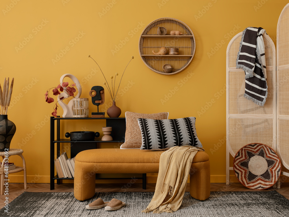 Interior design of cozy living room interior with yellow bench, black consola, patterned pillows, wooden partition wall, vase with dried flowers and personal accessories. Home decor. Template.