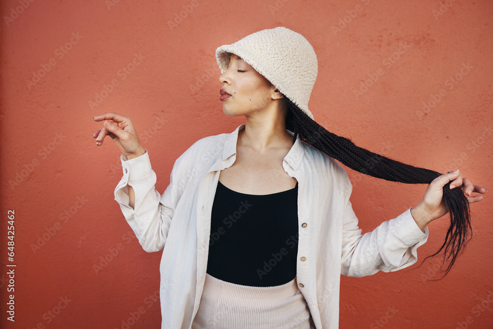 Fashion, hair and African woman orange background with trendy outfit, cool clothes and style for glamour. Beauty, makeup and person by wall with confidence, hairstyle and cosmetics in urban town