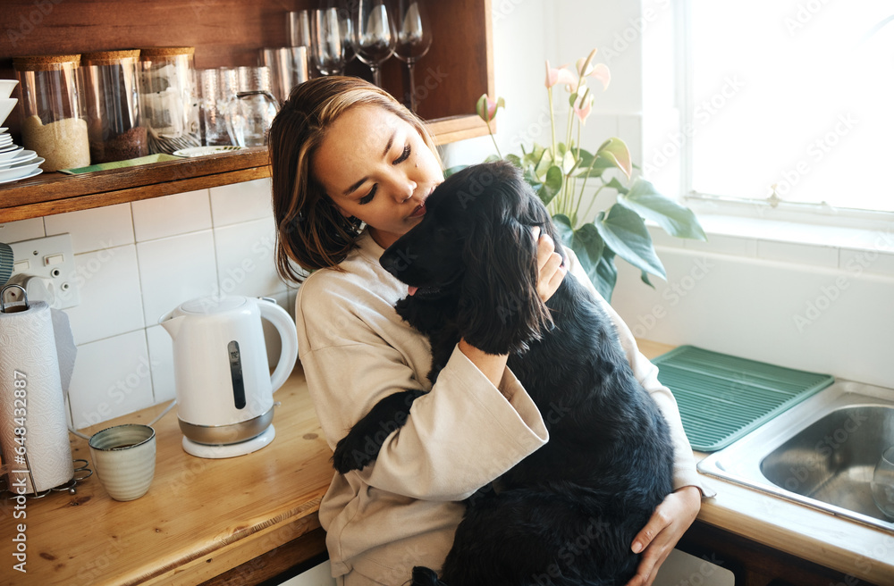 Hug, love and woman with a dog in home kitchen to relax and play with animal. Pet owner, happiness and asian person playing with companion, care and wellness or friendship in cozy apartment