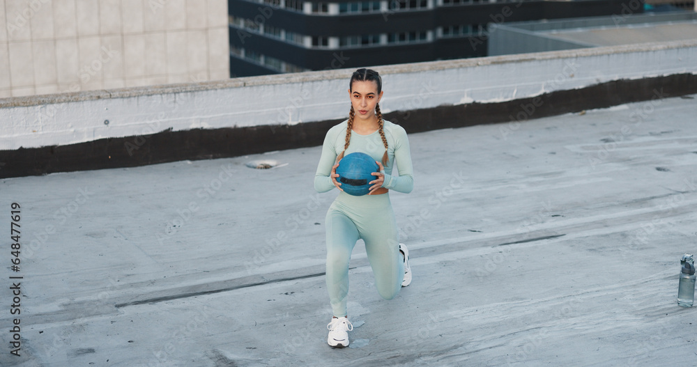 Fitness, medicine ball and woman athlete in the city for a health, wellness and cardio workout or exercise. Equipment, sports and young female person training on building rooftop in urban town.