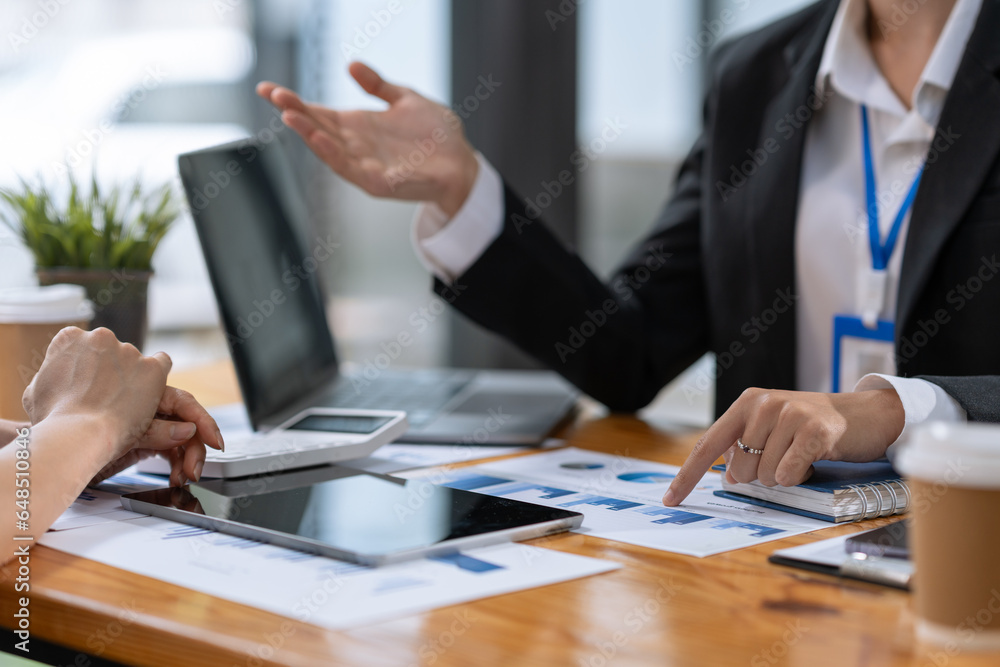 Two Businesswomen collaboration discussing working analyzing with financial data and marketing growth report graph in team presentation and brainstorming to strategy planning making profit of company