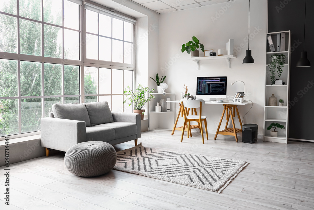 Interior of office with programmers workplace and sofa