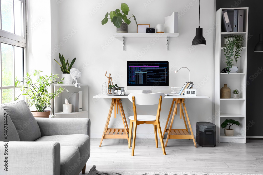 Interior of office with programmers workplace and sofa