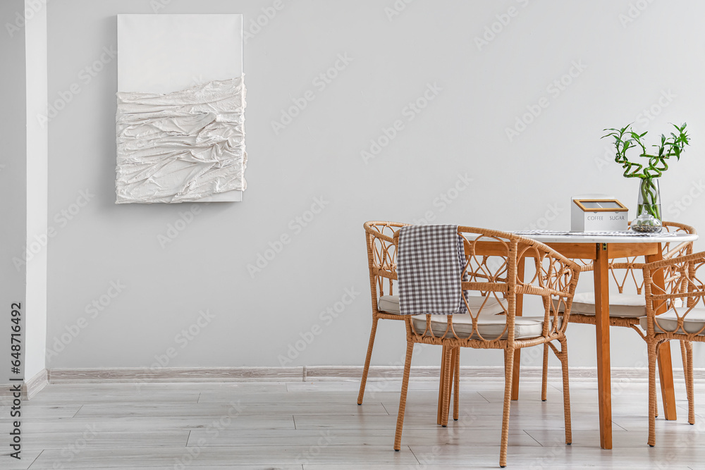 Interior of modern dining room with painting, table and chairs