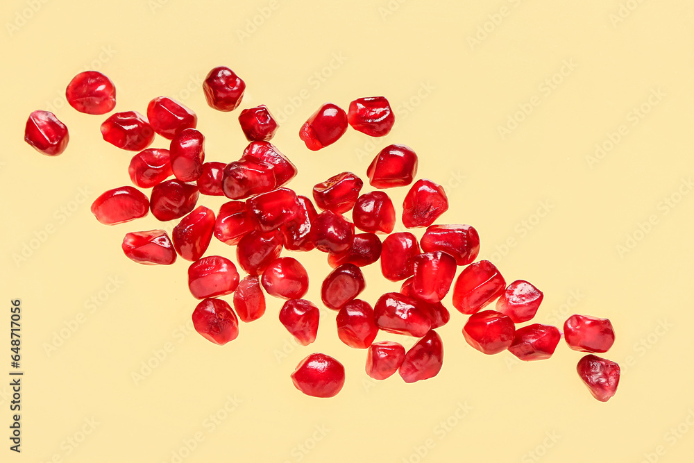 Fresh pomegranate with seeds on yellow background