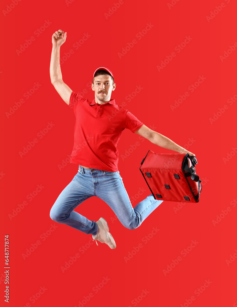 Jumping courier with bag on red background