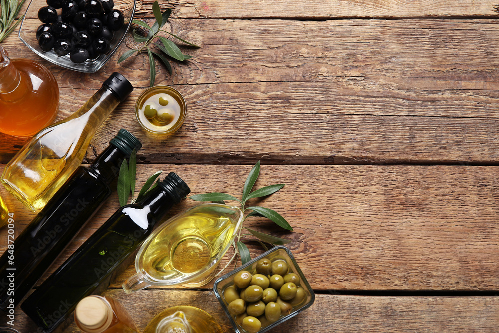 Different glassware with fresh olive oil on wooden background