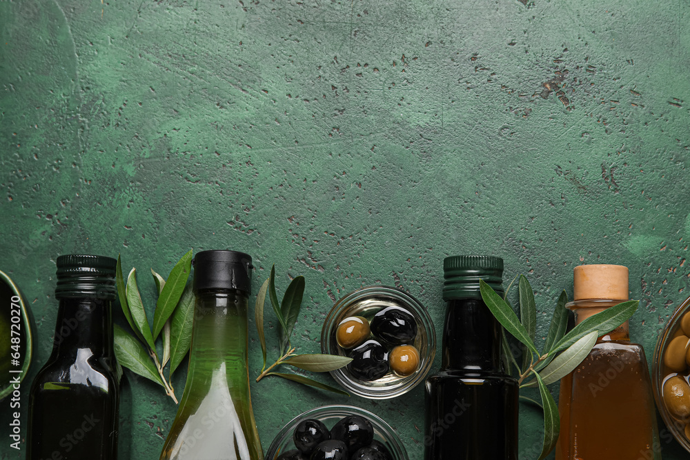 Different bottles of fresh olive oil on green background