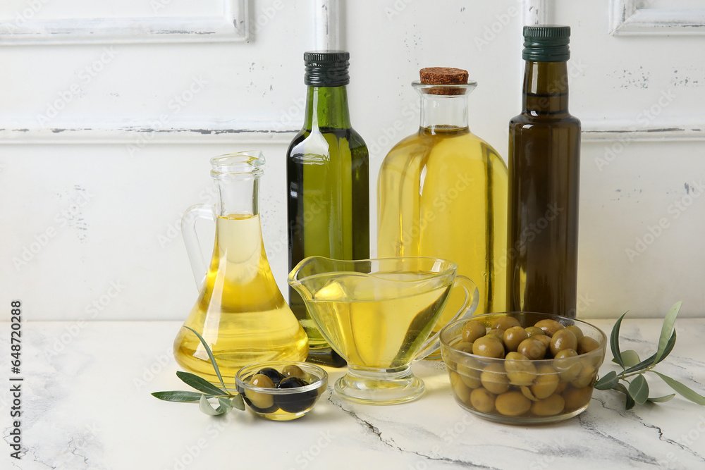 Different glassware of fresh olive oil on table