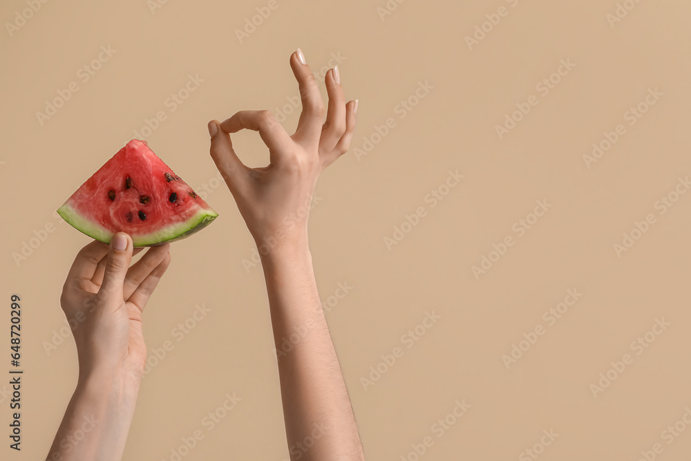 Female hands with slice of ripe watermelon on beige background