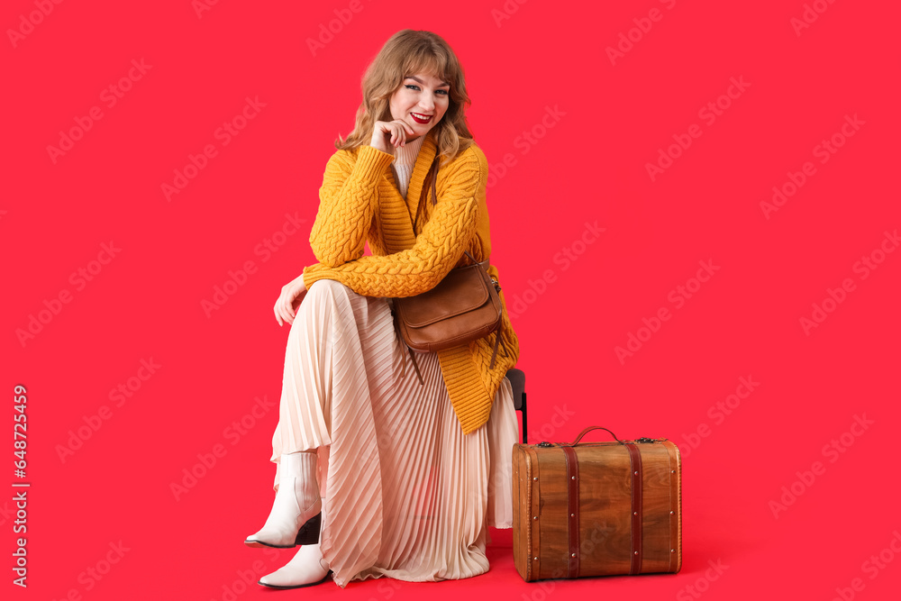 Stylish young woman in fall clothes with bags on red background