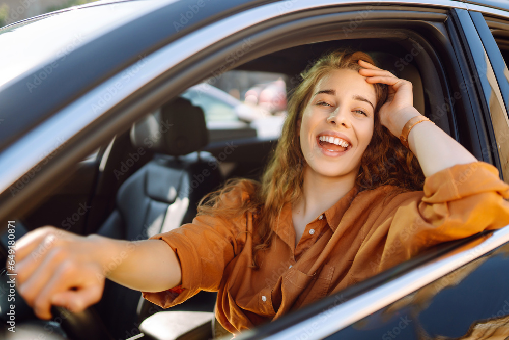 Emotional woman drives a car. Beautiful woman driving a car in the city. The concept of fast movement, traveling by car.