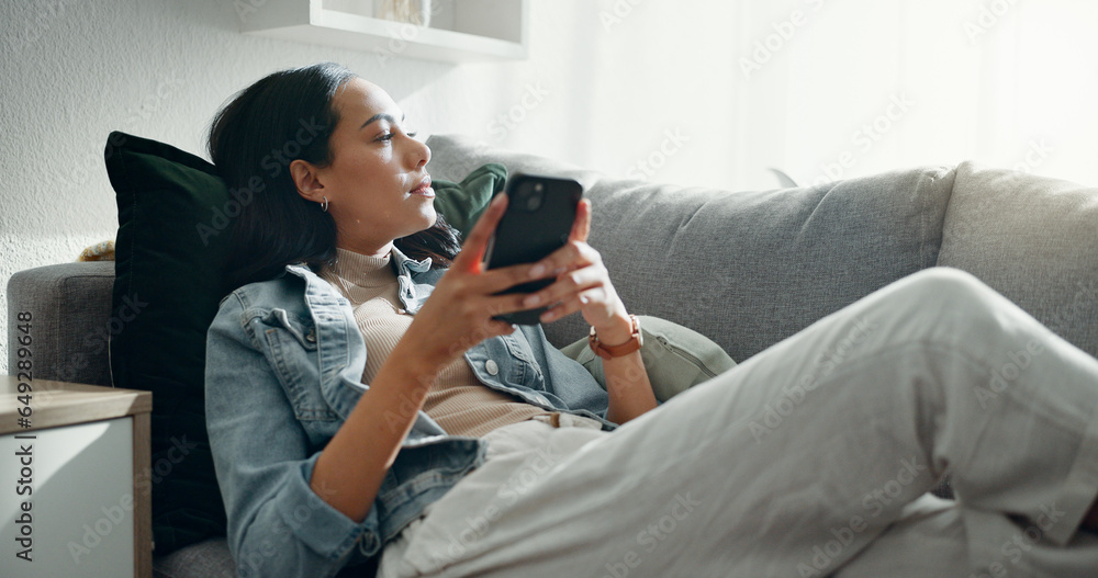 Woman, thinking and typing on smartphone on sofa, scroll social media and reading notification at home. Cellphone, relax and search connection, download digital app and mobile contact in living room