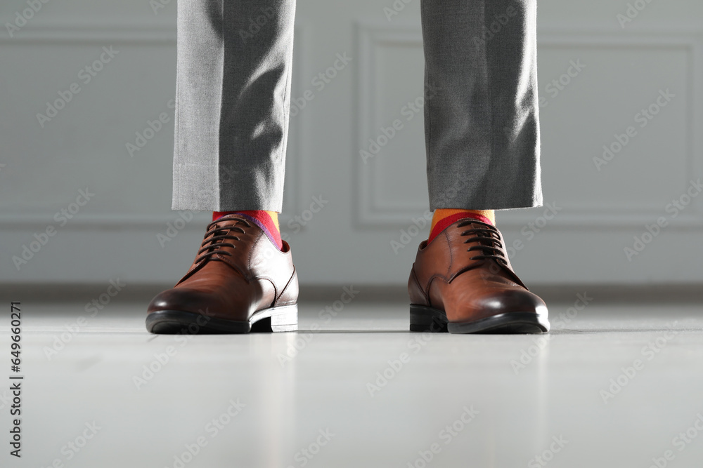 Man wearing stylish shoes and colorful socks indoors, closeup